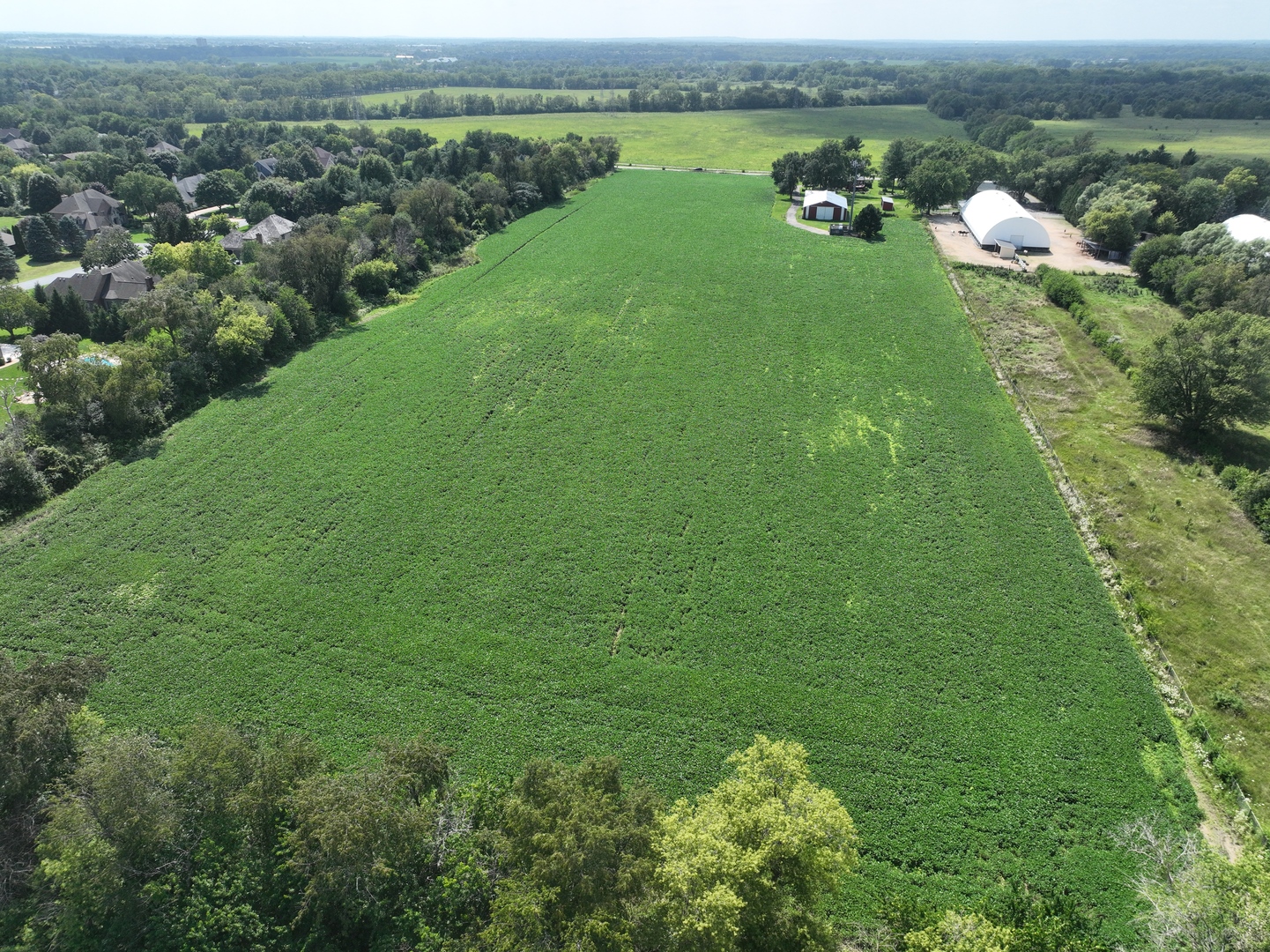 Lot 0 Munger Road Wayne, IL 60184 - Photo 3 of 11 an aerial view of green landscape with trees houses and lake view