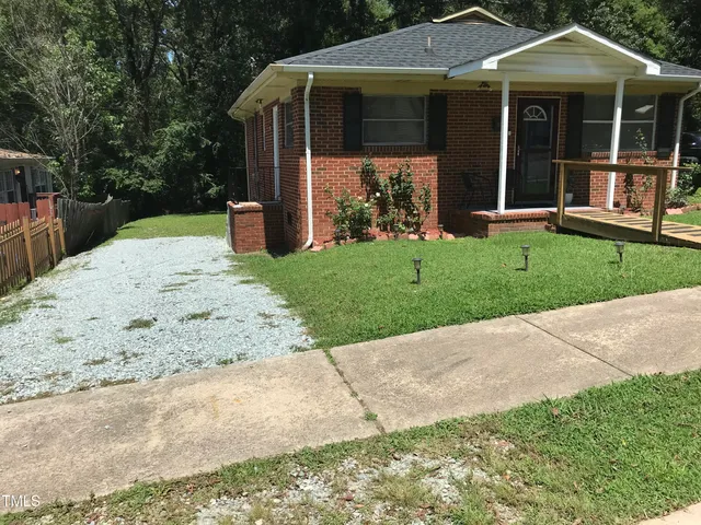 a view of a house with a yard and pathway