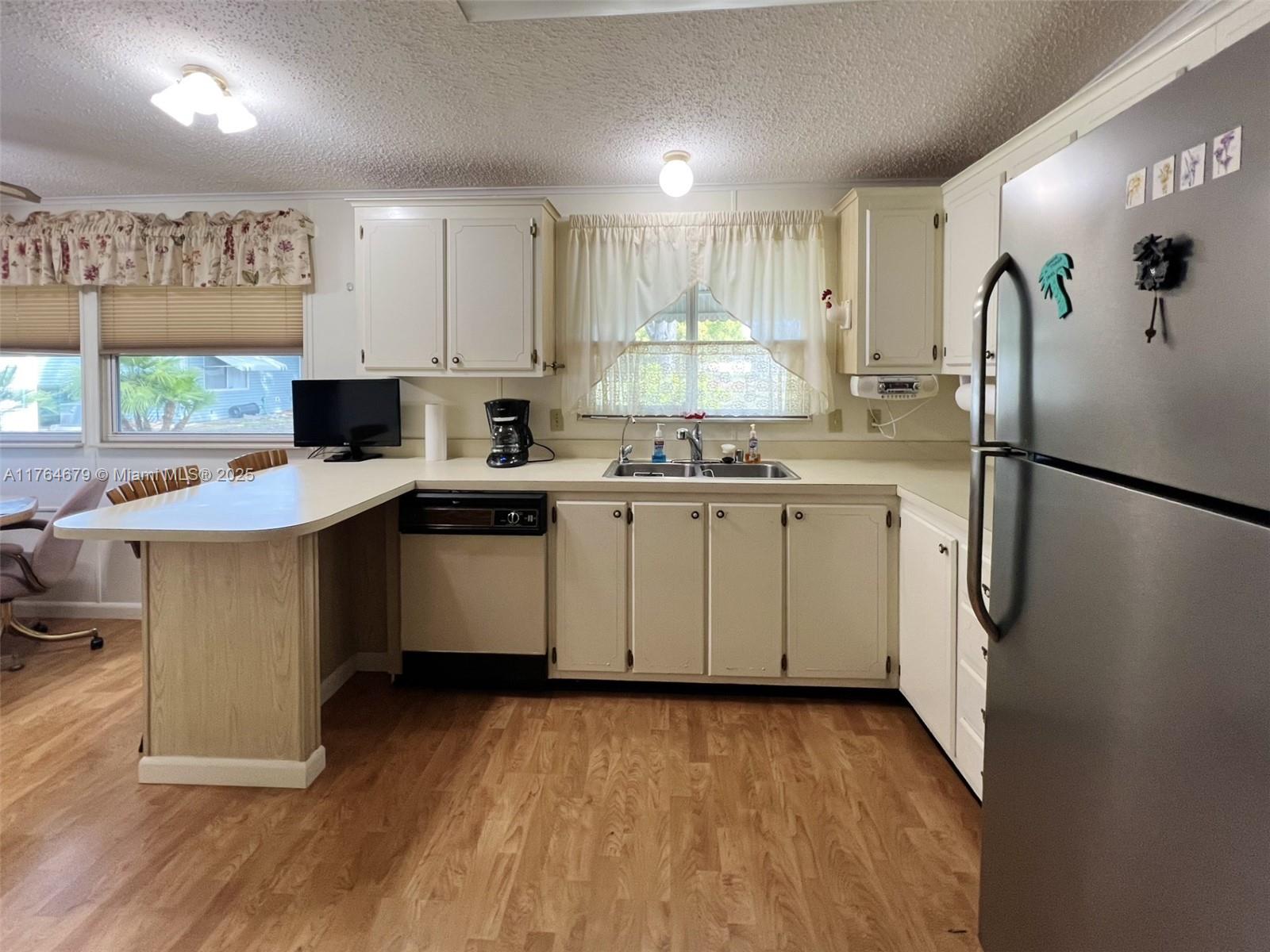 6367 Southwest 83rd Place Ocala, FL 34476 - Photo 25 of 47 a kitchen with a sink a refrigerator a window and cabinets