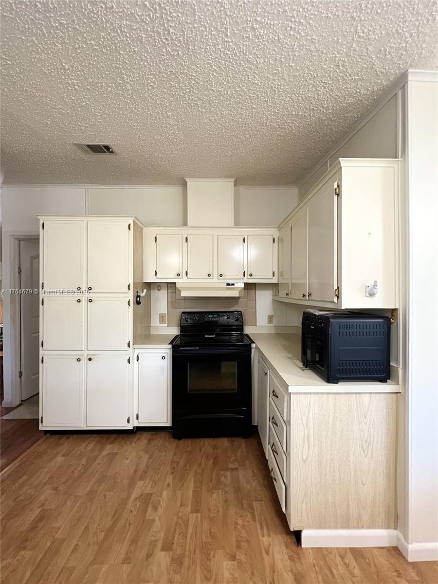 6367 Southwest 83rd Place Ocala, FL 34476 - Photo 27 of 47 a kitchen with a sink a stove top oven and white kitchen