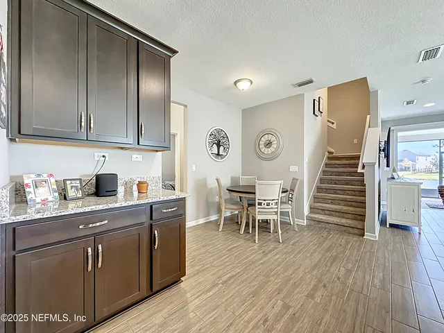 a kitchen with stainless steel appliances granite countertop a sink a stove and a wooden floors