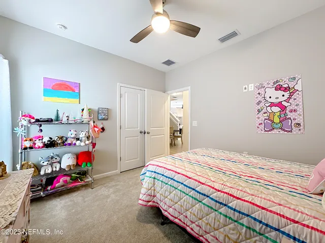 a bedroom with a large bed and a chandelier fan