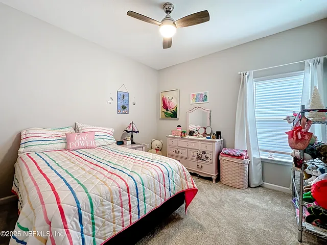 a living room with furniture and a ceiling fan