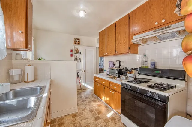 a kitchen with a stove a refrigerator and a sink