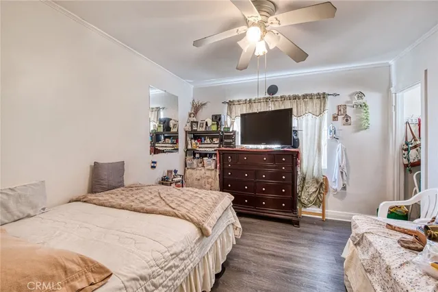 a bedroom with a bed and a flat tv screen on dresser