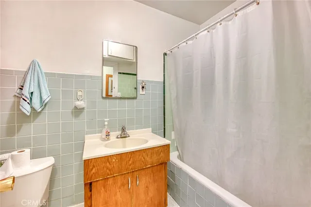 a bathroom with a sink a toilet and shower curtain