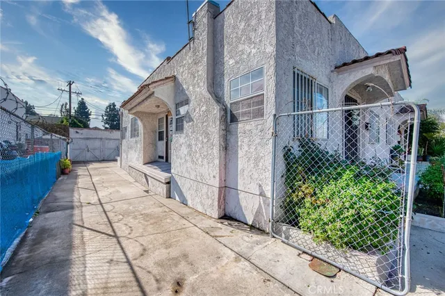 a front view of a house with a yard and potted plants
