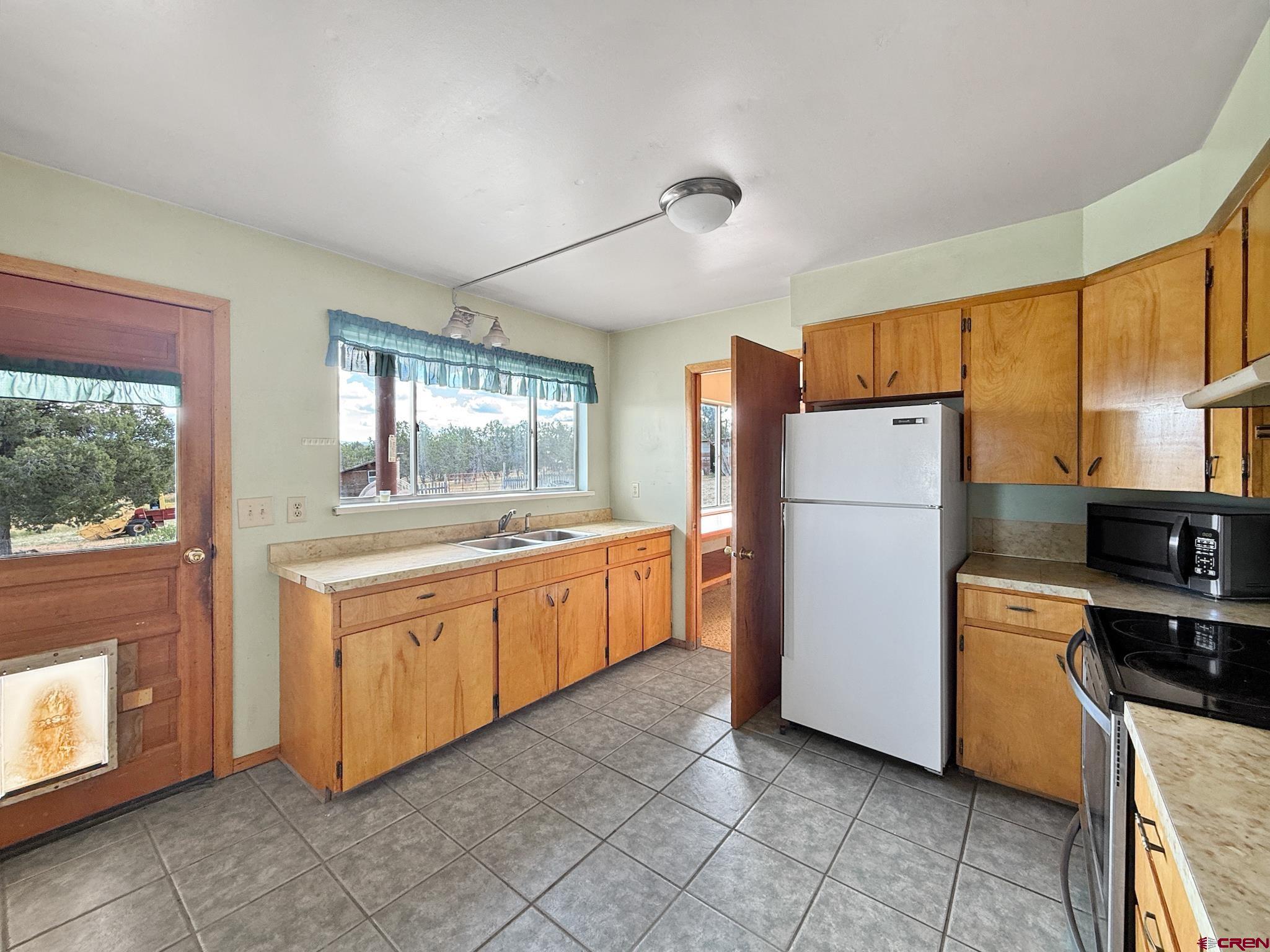 34706 Fruitland Mesa Road Crawford, CO 81415 - Photo 15 of 45 a kitchen with refrigerator cabinets and wooden floor