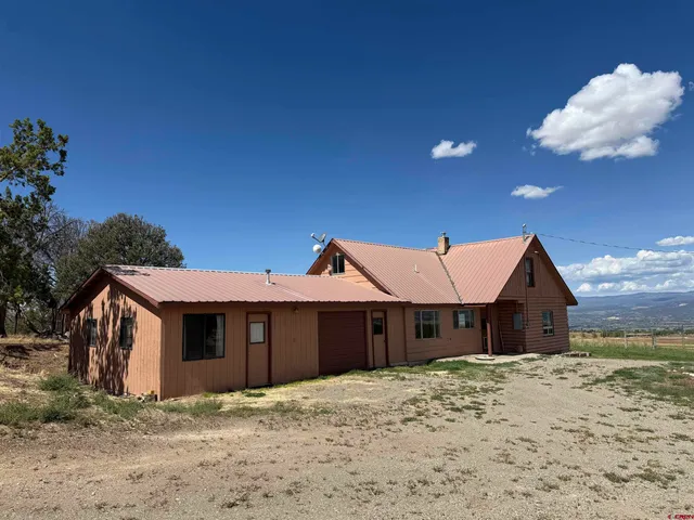 a view of a barn house next to a yard with wooden fence