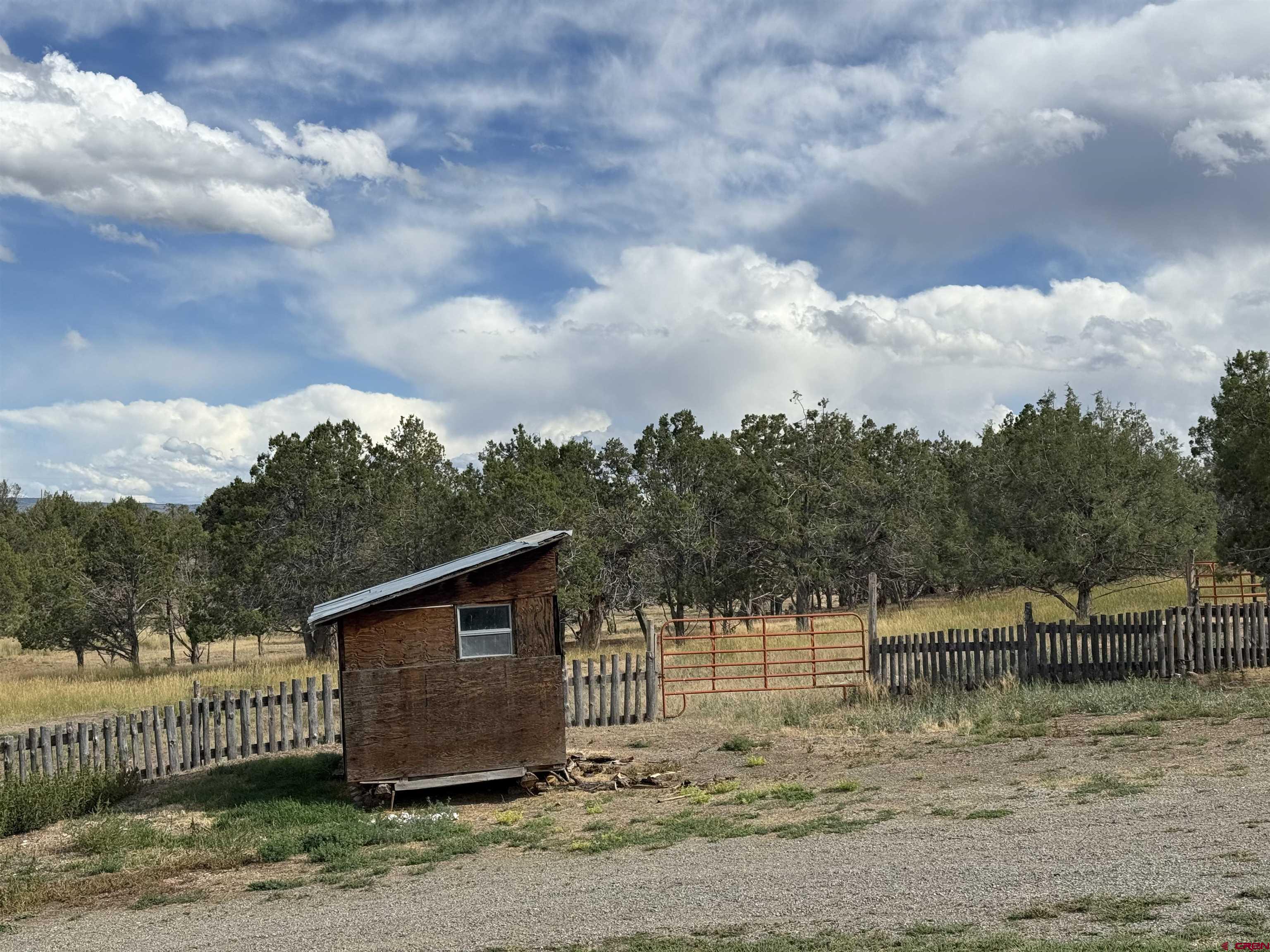 34706 Fruitland Mesa Road Crawford, CO 81415 - Photo 41 of 45 a view of a barn house next to a yard with wooden fence