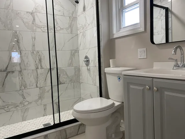 a bathroom with a sink a toilet and shower