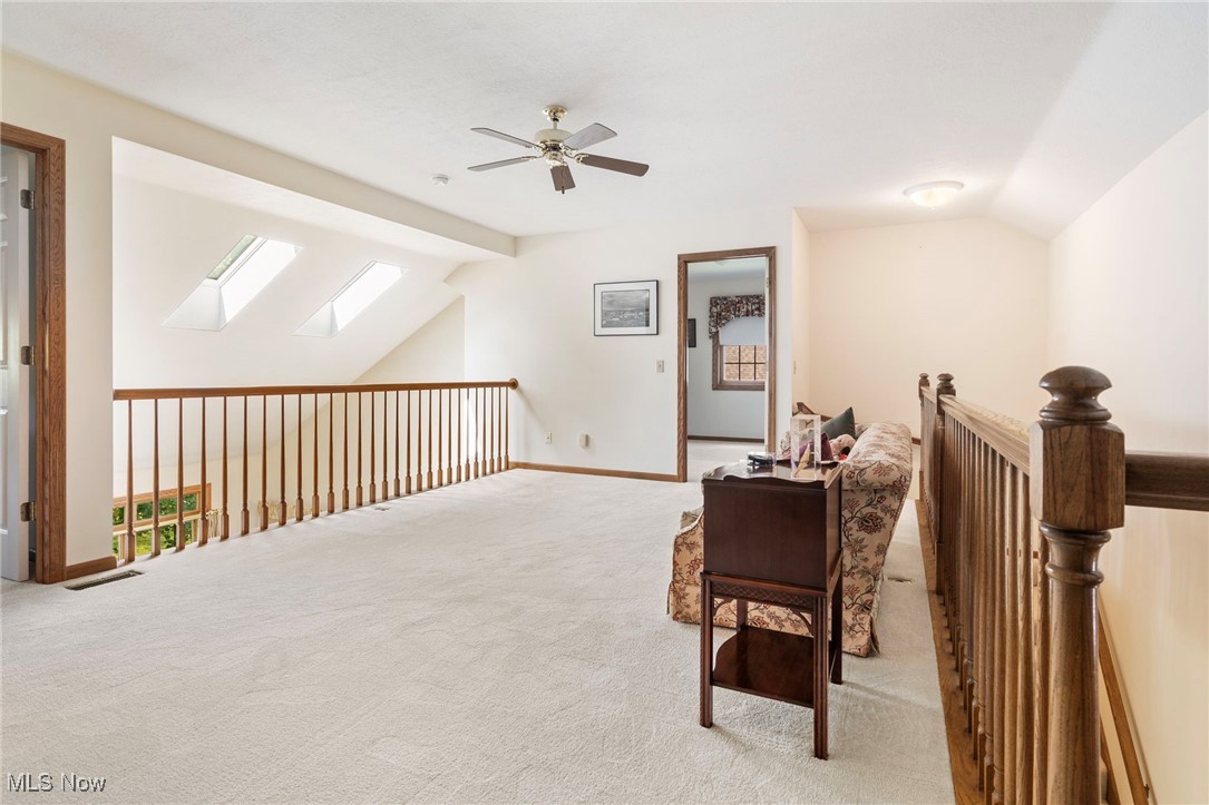 2503 Charing Cross Road Northwest Canton, OH 44708 - Photo 25 of 30 Living area featuring vaulted ceiling with skylight, ceiling fan, and light carpet