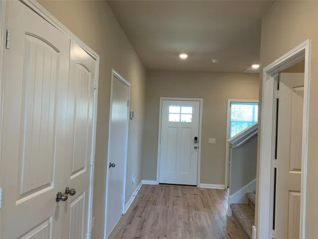 a view of a hallway with wooden floor and closet