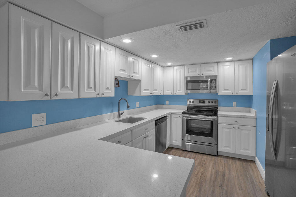 715 South Ocean Drive, Unit G Fort Pierce, FL 34949 - Photo 15 of 24 a kitchen with stainless steel appliances a refrigerator stove and sink