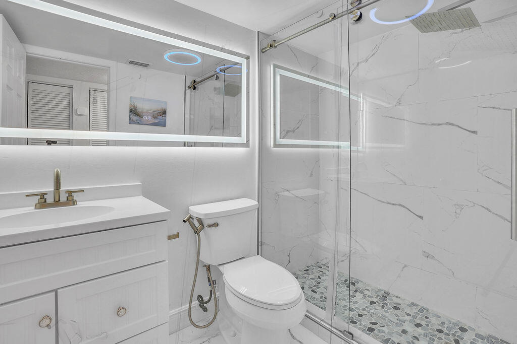 715 South Ocean Drive, Unit G Fort Pierce, FL 34949 - Photo 18 of 24 a bathroom with a sink toilet vanity and shower