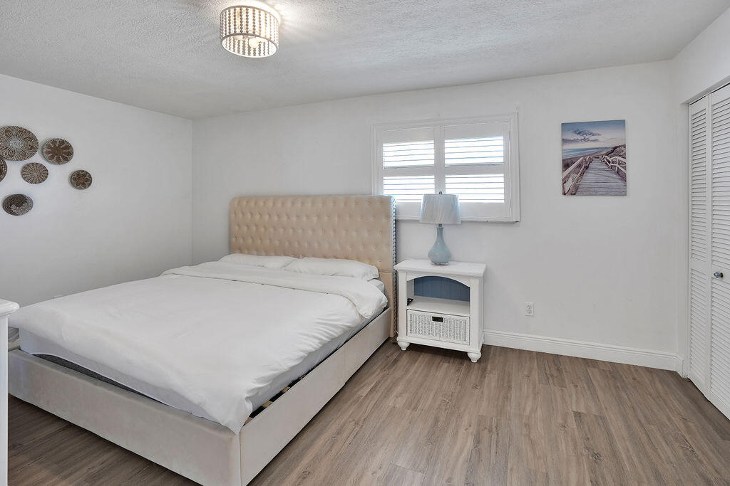 715 South Ocean Drive, Unit G Fort Pierce, FL 34949 - Photo 20 of 24 a bed room with a bed and a night stand