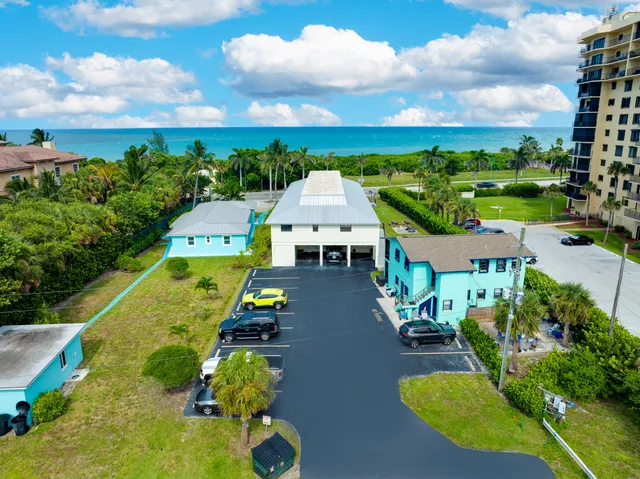a view of a house with a big yard and palm trees