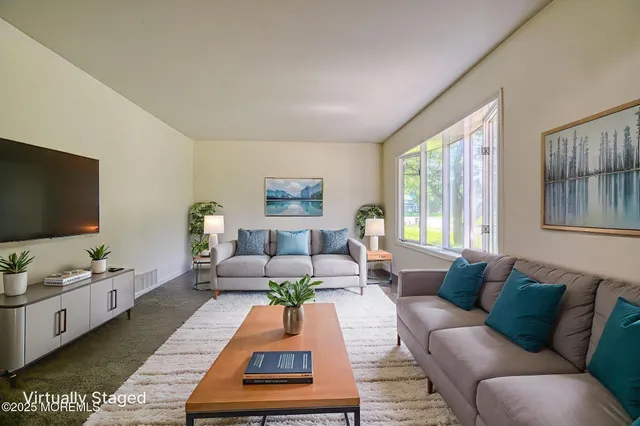 a living room with furniture fireplace and a large window