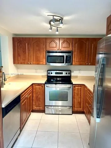 a kitchen with stainless steel appliances granite countertop a stove microwave and refrigerator