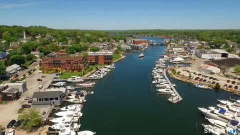 an aerial view of a city with lots of residential buildings ocean and mountain view in back