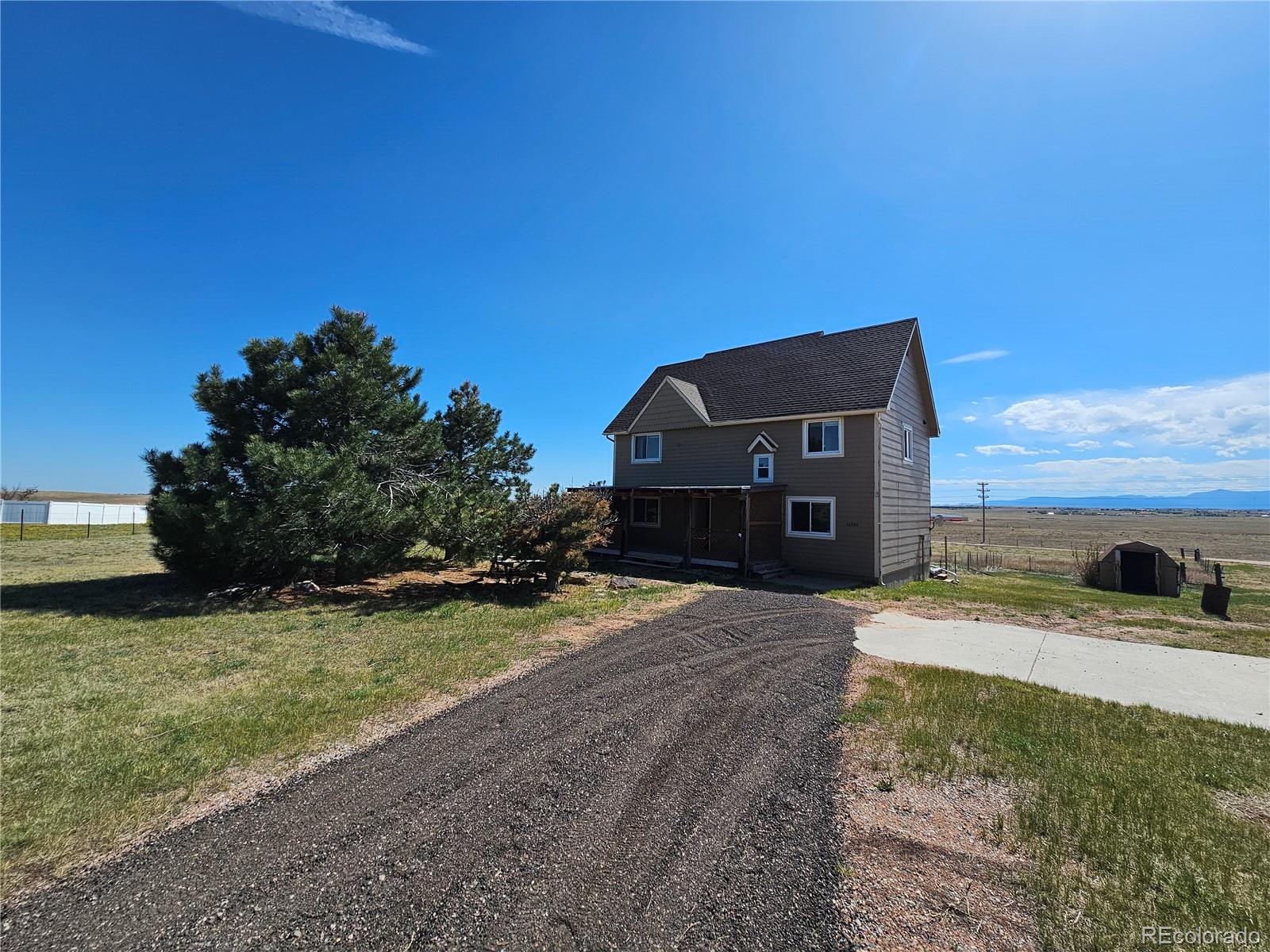 16985 Sage Crest Road Peyton, CO 80831 - Photo 1 of 25 a car parked in front of a house with a yard