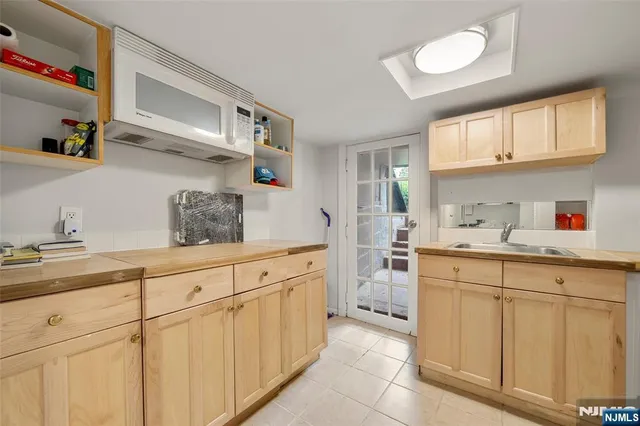 a kitchen with white cabinets and sink