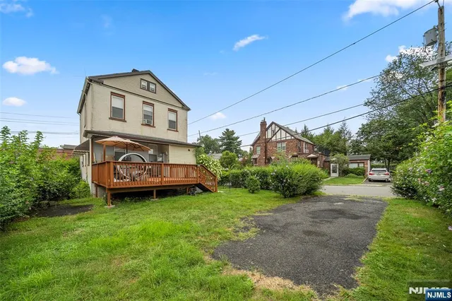 a view of a big house with a big yard and large trees
