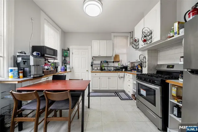 a kitchen with stainless steel appliances granite countertop a sink a stove and a refrigerator