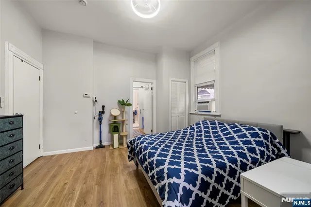 a bedroom with a bed and dresser with mirror