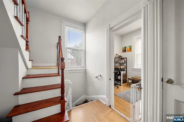 a view of a hallway with wooden floor and entryway