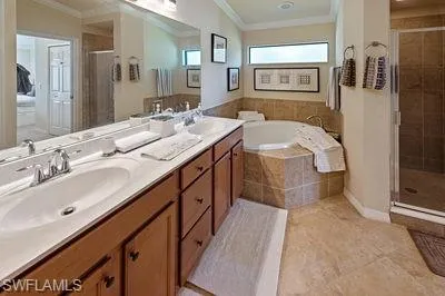a spacious bathroom with a double vanity sink a mirror and a bathtub