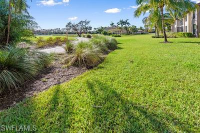 9844 Venezia Circle, Unit 721 Naples, FL 34113 - Photo 23 of 50 a view of a lake with a building in the background