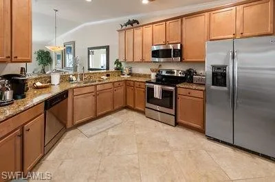a kitchen with stainless steel appliances granite countertop a stove top oven a sink and dishwasher
