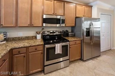 a kitchen with stainless steel appliances granite countertop a stove a refrigerator and a microwave