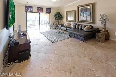 a living room with furniture a flat screen tv and a large window