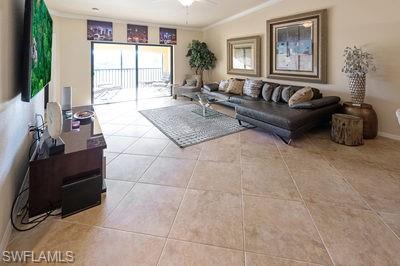 9844 Venezia Circle, Unit 721 Naples, FL 34113 - Photo 9 of 50 a living room with furniture a flat screen tv and a large window
