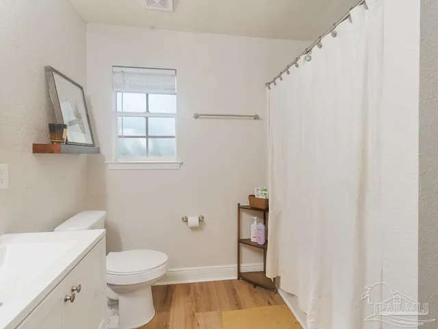 a bathroom with a toilet a sink and a window