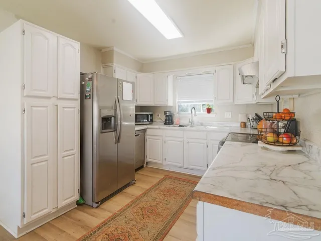 a kitchen with white cabinets and white appliances