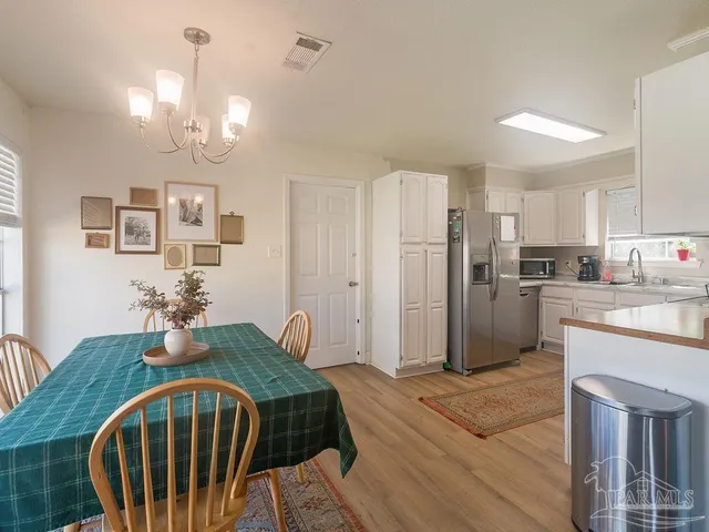 a kitchen with stainless steel appliances granite countertop a refrigerator a stove a sink dishwasher with a dining table and chairs