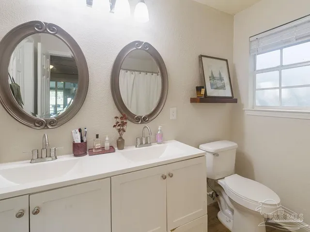 a bathroom with a toilet a sink and a mirror