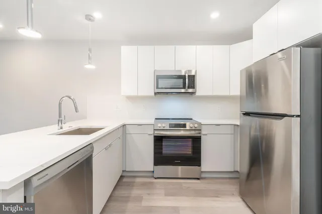 a kitchen with stainless steel appliances granite countertop a refrigerator sink and stove