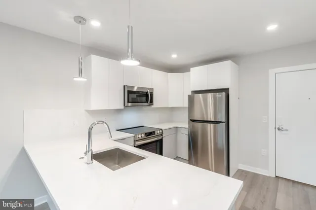 a kitchen with stainless steel appliances a refrigerator sink and microwave