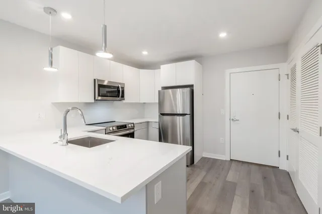 a kitchen with kitchen island a sink appliances and cabinets