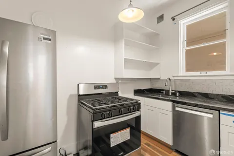 a kitchen with granite countertop a stove and a sink