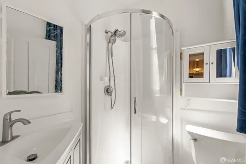 a bathroom with a sink a toilet and shower