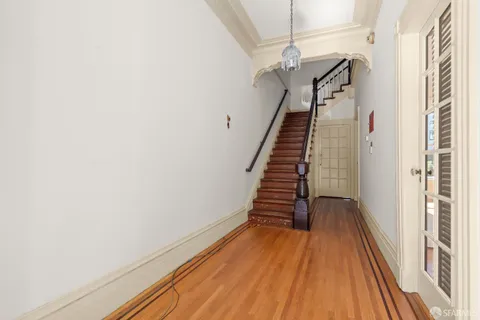 a view of a hallway with wooden floor and staircase