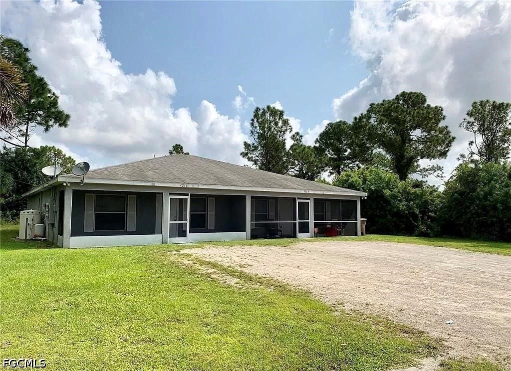 4750 28th Street Southwest Lehigh Acres, FL 33973 - Photo 1 of 1 a view of a house with floor to ceiling windows and a big yard