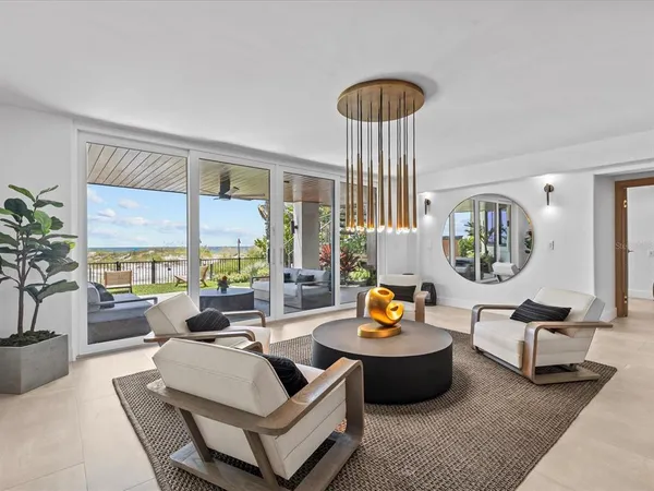 a living room with furniture kitchen view and a chandelier