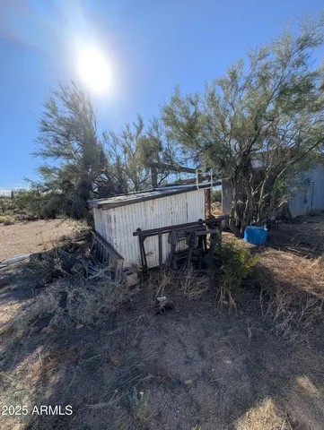 a view of backyard with barbeque grill and wooden fence