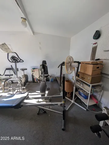 a living room with furniture and a gym machine